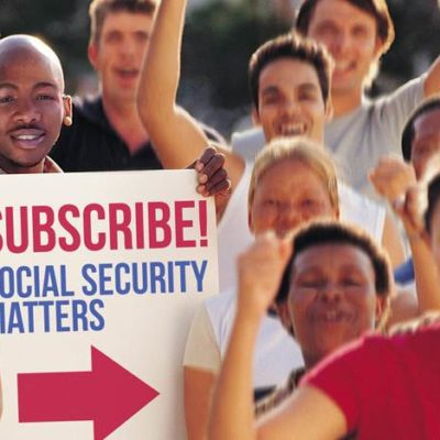 People cheering while a man holds a sign