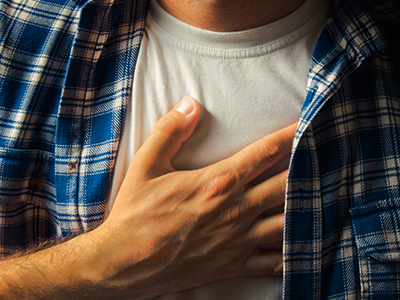 A man holds his hand over his chest.