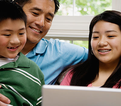 A happy family looks at a computer.