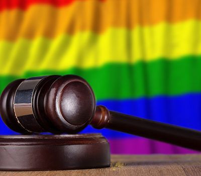 Court gravel laying in front of a rainbow flag