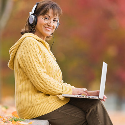 happy woman outside with laptop