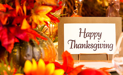 Happy Thanksgiving Text on a card surrounded by Thanksgiving decorations