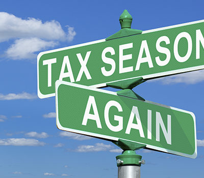 A picture of street signs that read tax season, and again.