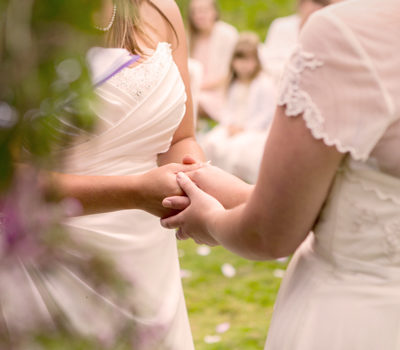 Bride holding hands with her bridesmaid.