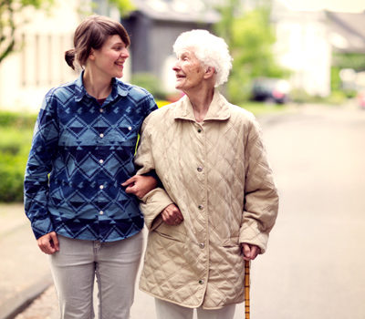 A woman walking with elderly woman