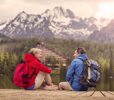 A man and woman with backpacks, looking at a mountain