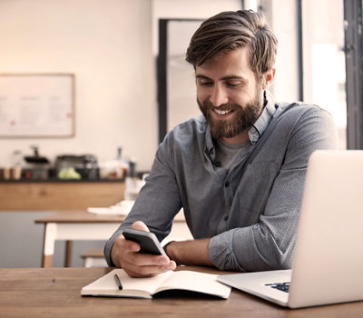 A man sitting at a table, looking at his cell phone