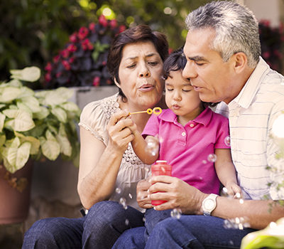 Grandparents and granddaughter making bubbles