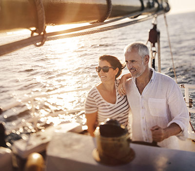 A senior active couple enjoying the fresh ocean breeze on their leasure cruise on their yacht