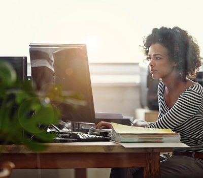 A woman using a computer while sitting at a desk