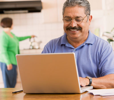 A smiling man using a laptop