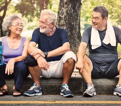 Three elderly people siting on a stoop