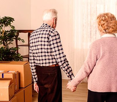 An elderly man and woman holding hands