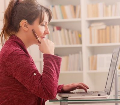 A woman sitting at a desk and using a laptop