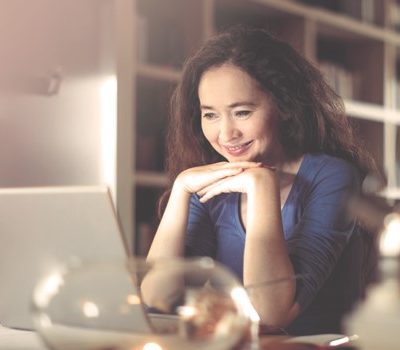 A woman sitting at a desk and using a laptop