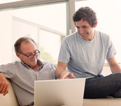 A father and son watching a video on a laptop