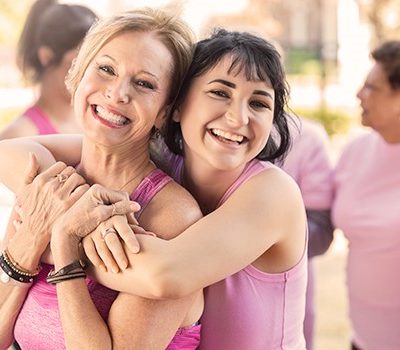 Women hugging, wearing pink