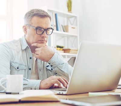 A man sitting at a desk using a laptop