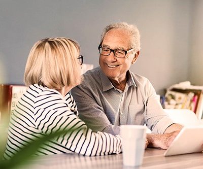 An elderly couple smiling at one another