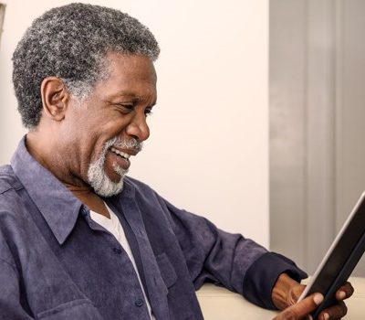 An older man reading from a tablet device