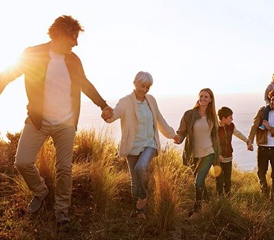 A family holding hands while hiking up a hill