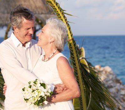 An elderly couple's wedding photo on a beach