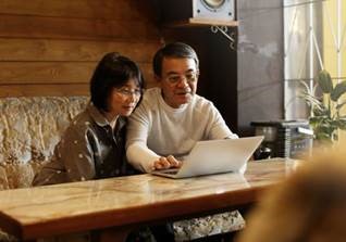 An elderly couple looking at a laptop together