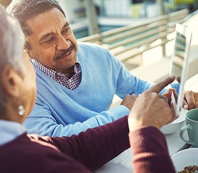 An older couple looking at a tablet device