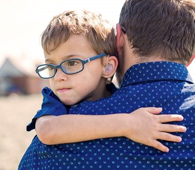 A boy being held by his father