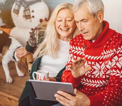 An older couple looking at a tablet device during Christmas