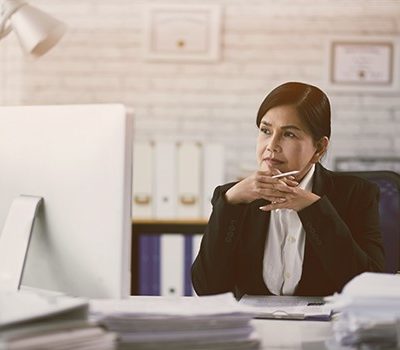 A woman reading a document on a computer monitor