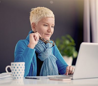 A woman sitting at a desk and using a laptop