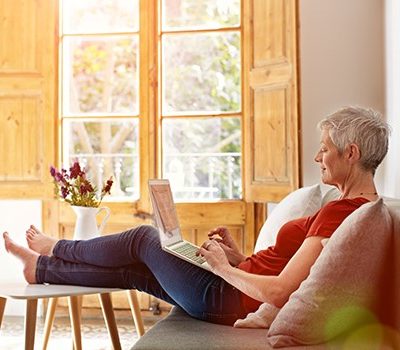 A woman sitting on a couch using a laptop