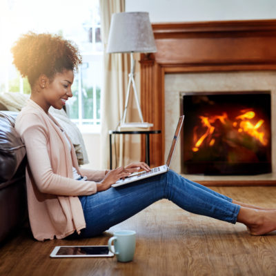 A woman sitting on the floor using a laptop