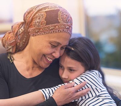 A woman hugging younger girl