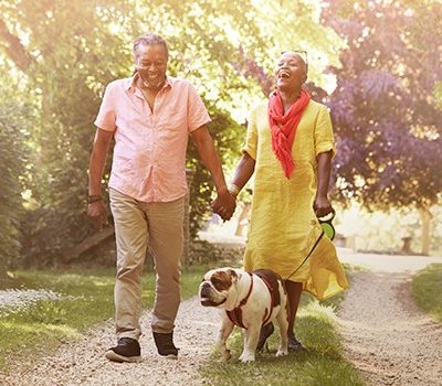 An older couple walking a dog