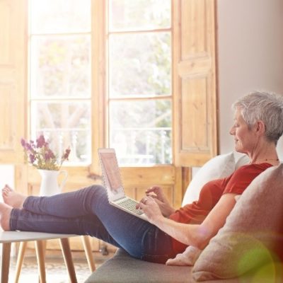 woman relaxing on couch, using laptop