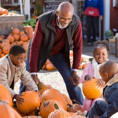 A grandfather and grandkids at a pumpkin patch