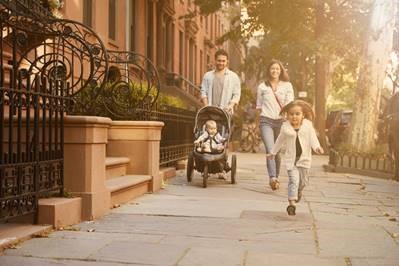 A family walking down a sidewalk in a city neighborhood