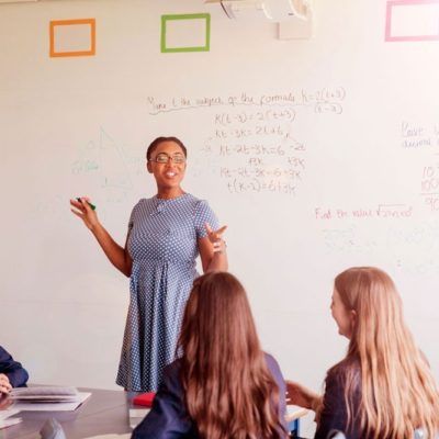 A teacher educating her classroom about algebraic equations