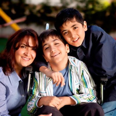 A mother and her two sons smiling for the camera