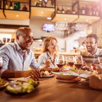 A group of friends laughing while having dinner