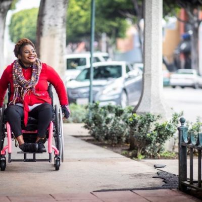 A woman strolling down the street in a wheelchair