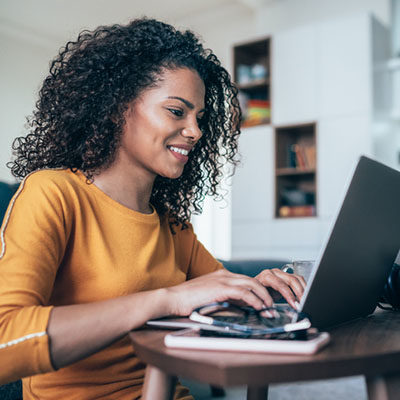 Young modern woman working from home, using laptop in quarantine