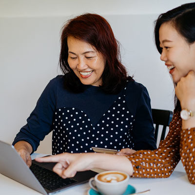 mother and daughter using laptop online