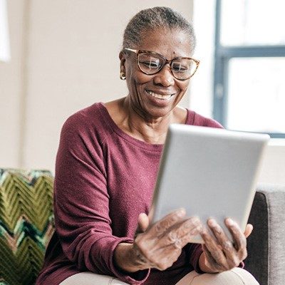 Woman sitting down checking information on a tablet