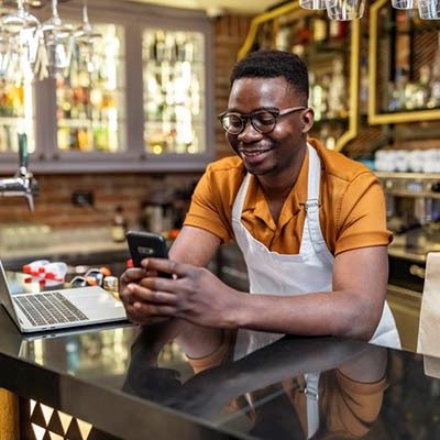 young man at counter reviewing his cell phone