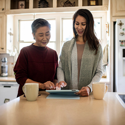 mother and daughter reviewing items on a tablet together