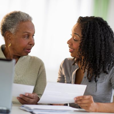 Daughter helping mother pay bills online