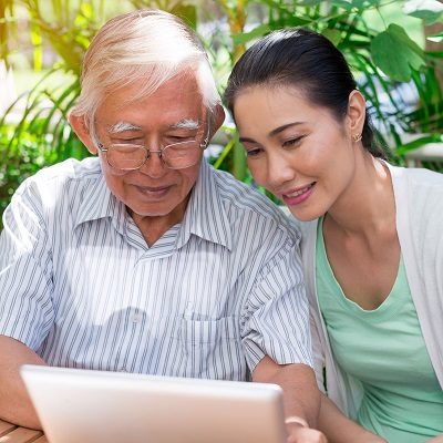 daughter helping father apply for benefits on tablet